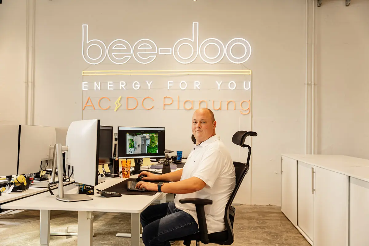 bee-doo Mitarbeiter AC/DC Planung – Neon-Logo