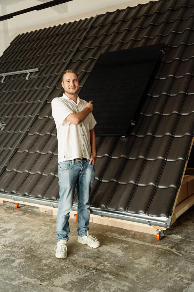 Mitarbeiter der bee-doo GmbH zeigt auf ein Solarmodul und erklärt die Dachmontage einer Photovoltaikanlage in Bielefeld